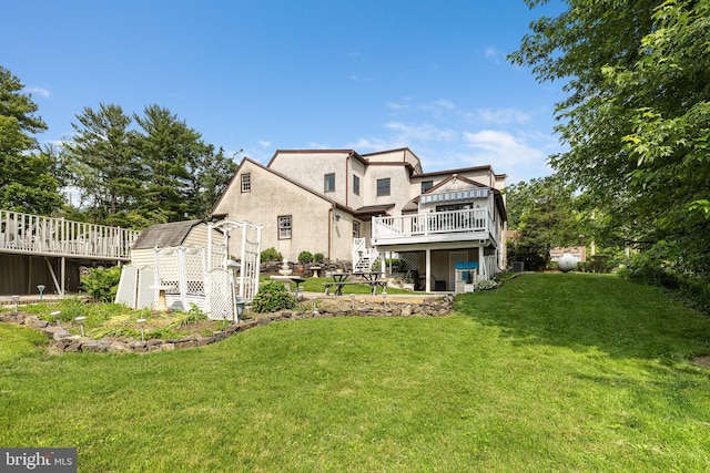 1445 Farmington Ave, Pottstown, PA 19464 - rear view of property featuring a wooden deck, a yard, stucco siding, stairway, and an outdoor structure