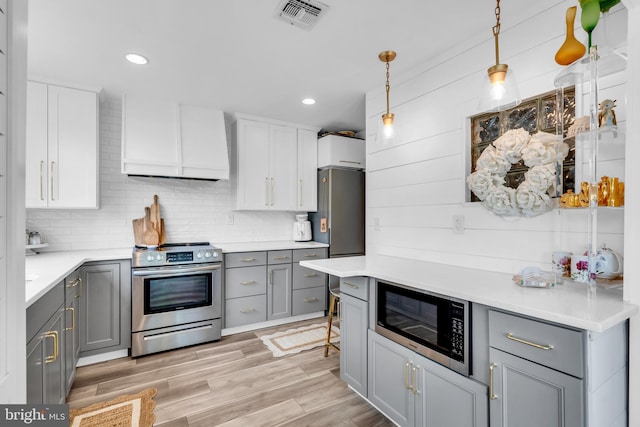 19 Warwick Way, Southampton, NJ 08088 - kitchen featuring stainless steel appliances, gray cabinets, custom range hood, pendant lighting, and light countertops