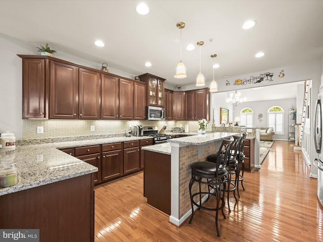 5910 Constance Way, New Market, MD 21774 - kitchen featuring appliances with stainless steel finishes, a kitchen bar, glass insert cabinets, light stone countertops, and recessed lighting