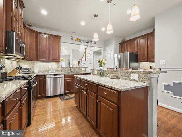 5910 Constance Way, New Market, MD 21774 - kitchen featuring stainless steel appliances, a kitchen island, decorative backsplash, light wood-type flooring, and decorative light fixtures