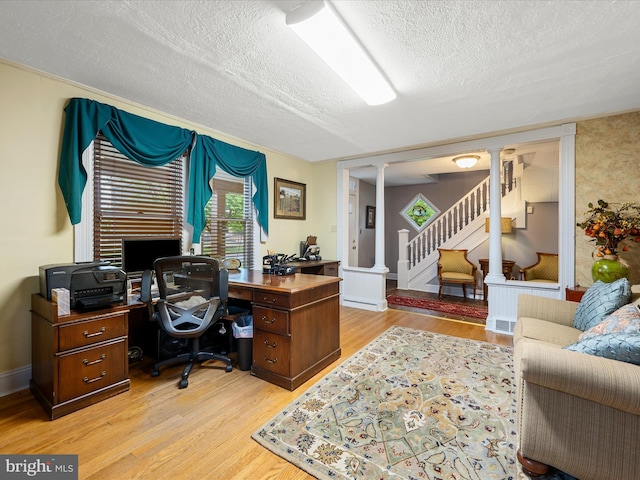 507 S Fairfax Blvd, Charles Town, WV 25414 - home office with ornate columns, a textured ceiling, and light wood-type flooring
