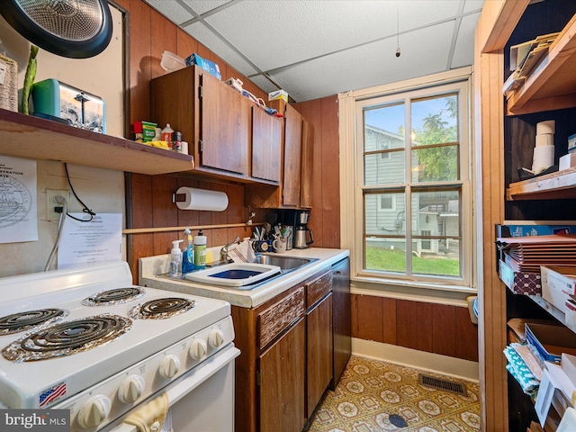 507 S Fairfax Blvd, Charles Town, WV 25414 - kitchen with white stove, wooden walls, light countertops, plenty of natural light, and brown cabinets