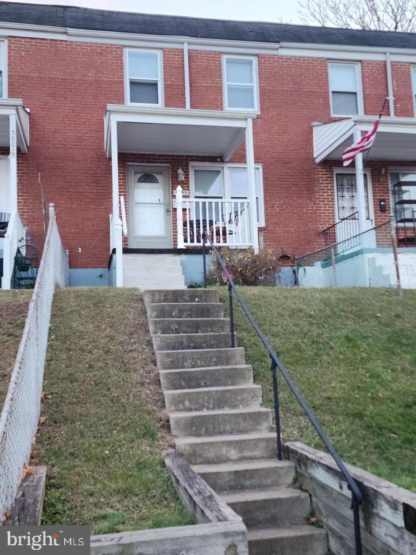 3803 Patapsco Ave, Baltimore, MD 21229 - view of front facade with brick siding, stairway, a porch, and a front yard