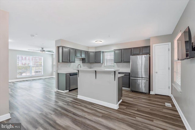 6116 Baldridge Ter, Frederick, MD 21701 - kitchen with appliances with stainless steel finishes, light countertops, dark wood-style floors, decorative backsplash, and gray cabinets
