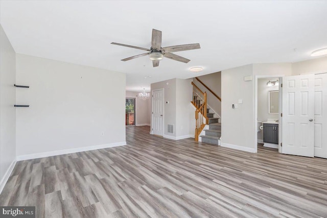 6116 Baldridge Ter, Frederick, MD 21701 - unfurnished living room featuring light wood-style floors, stairway, ceiling fan, and a chandelier