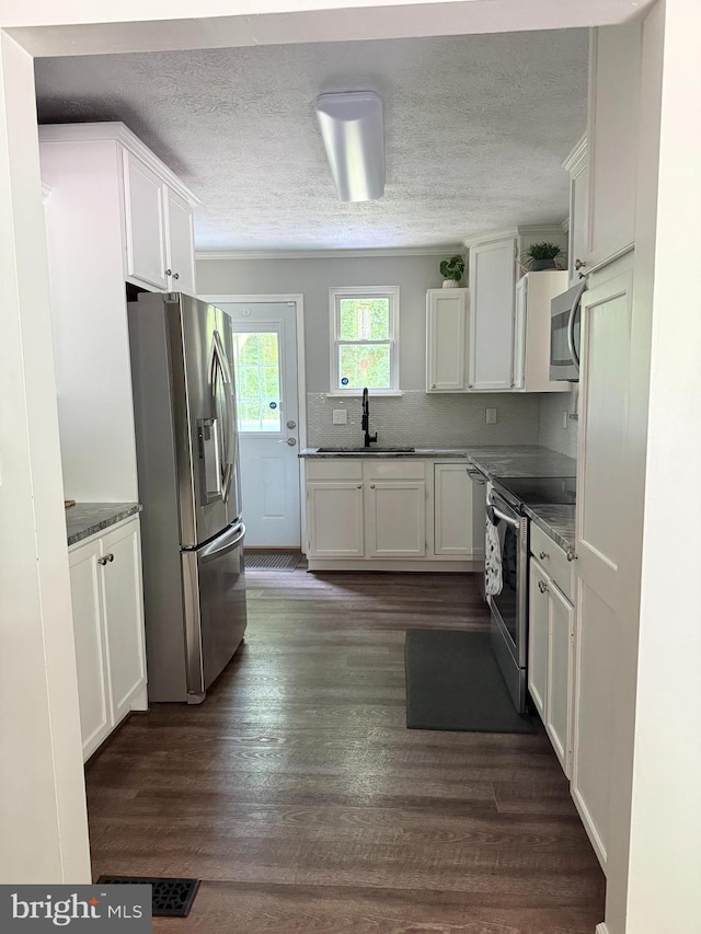 4123 Cassell Blvd, Prince Frederick, MD 20678 - kitchen featuring appliances with stainless steel finishes, white cabinetry, tasteful backsplash, a textured ceiling, and dark wood-style flooring