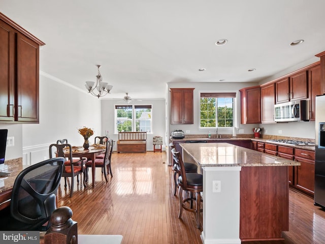 24847 Mason Dale Ter, Chantilly, VA 20152 - kitchen featuring stainless steel appliances, a chandelier, a kitchen island, a kitchen breakfast bar, and light stone counters