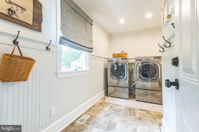 3 Cooper Ct, Sicklerville, NJ 08081 - laundry area with washer and clothes dryer, a wainscoted wall, and stone finish flooring