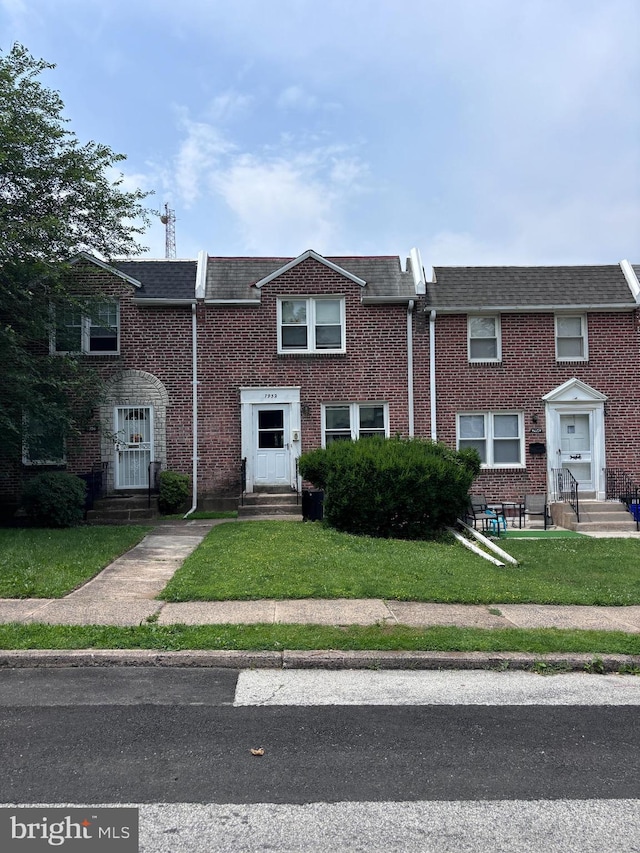 7952 Arlington Ave, Upper Darby, PA 19082 - townhome / multi-family property featuring entry steps, brick siding, a front lawn, and a shingled roof