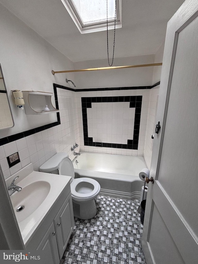 7952 Arlington Ave, Upper Darby, PA 19082 - full bathroom featuring tile walls, vanity, bathing tub / shower combination, tile patterned floors, and a skylight