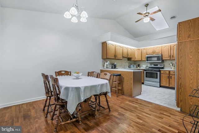 28 Abbey Ct, Carlisle, PA 17015 - kitchen featuring appliances with stainless steel finishes, a ceiling fan, a peninsula, lofted ceiling, and a kitchen bar