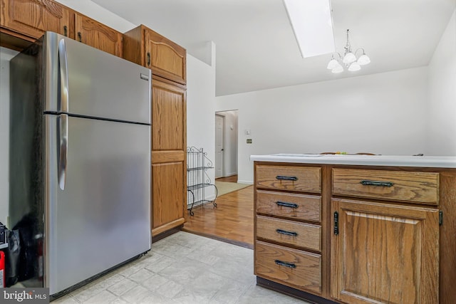 28 Abbey Ct, Carlisle, PA 17015 - kitchen with freestanding refrigerator, brown cabinetry, a skylight, and lofted ceiling