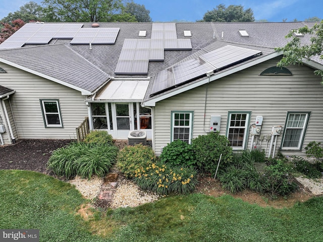 28 Abbey Ct, Carlisle, PA 17015 - back of property featuring roof with shingles, roof mounted solar panels, and a lawn