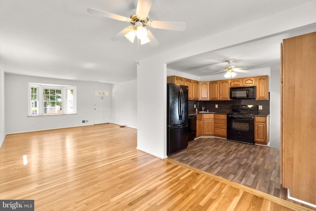1028 Marleigh Cir, Baltimore, MD 21204 - kitchen featuring black appliances, wood finished floors, ceiling fan, open floor plan, and backsplash