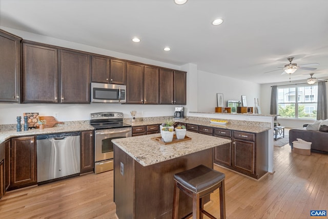 1254 Haden Pl, Crozet, VA 22932 - kitchen with appliances with stainless steel finishes, a peninsula, dark brown cabinetry, light wood-style floors, and recessed lighting