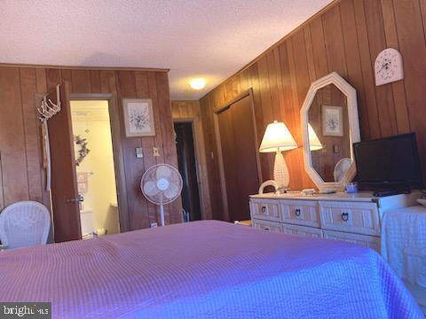 718 Mooring Rd Unit B203, Ocean City, MD 21842 - bedroom featuring wood walls and a textured ceiling
