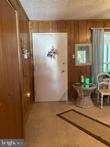 718 Mooring Rd Unit B203, Ocean City, MD 21842 - entryway featuring a textured ceiling, wood walls, and light colored carpet