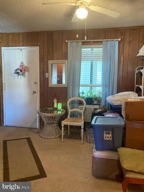 718 Mooring Rd Unit B203, Ocean City, MD 21842 - entrance foyer featuring wood walls, a textured ceiling, a ceiling fan, and light carpet