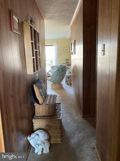 718 Mooring Rd Unit B203, Ocean City, MD 21842 - hall featuring wooden walls, a textured ceiling, and carpet floors