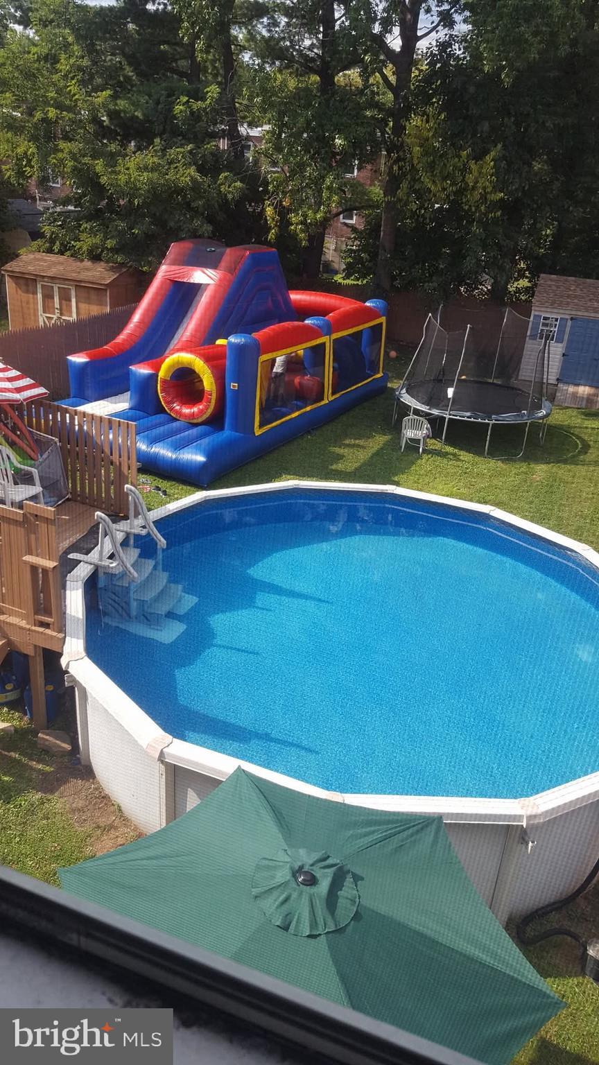 26 N Academy Ave, Glenolden, PA 19036 - outdoor pool featuring a trampoline, a storage shed, and a yard