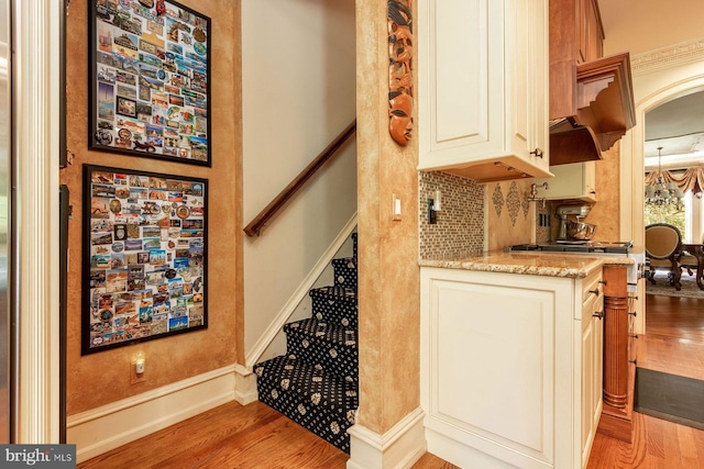 3500 Windy Bush Rd, New Hope, PA 18938 - kitchen featuring light wood-type flooring, light stone counters, arched walkways, and tasteful backsplash