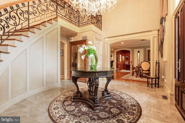 3500 Windy Bush Rd, New Hope, PA 18938 - entrance foyer featuring arched walkways, a decorative wall, a high ceiling, a chandelier, and stairs