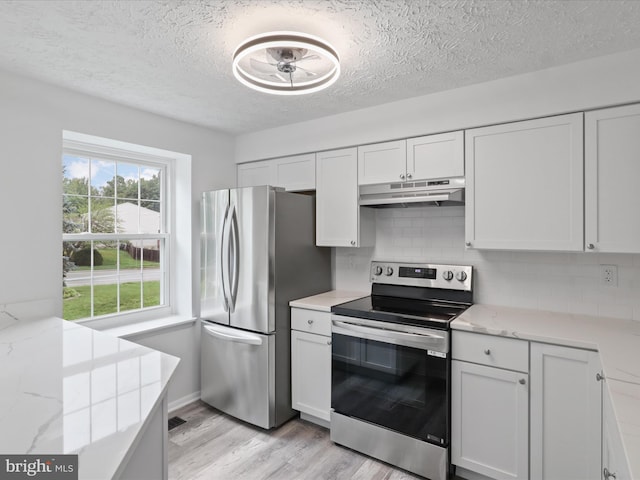 8456 Rocky Knob Ct, Lorton, VA 22079 - kitchen featuring appliances with stainless steel finishes, under cabinet range hood, light wood finished floors, tasteful backsplash, and a textured ceiling