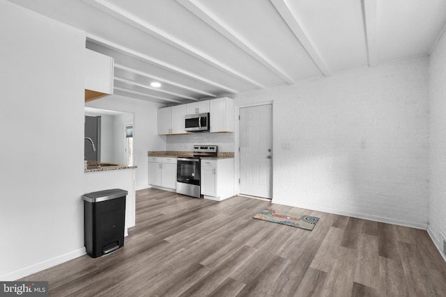 7012 Nashville Ct, Lanham, MD 20706 - kitchen featuring appliances with stainless steel finishes, white cabinetry, wood finished floors, beamed ceiling, and stone countertops