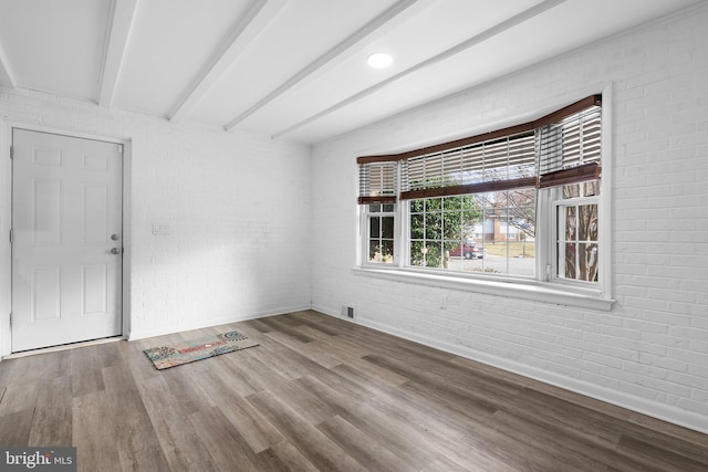 7012 Nashville Ct, Lanham, MD 20706 - unfurnished room with brick wall, wood finished floors, and beamed ceiling