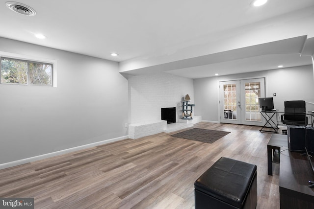 7012 Nashville Ct, Lanham, MD 20706 - living area featuring plenty of natural light, a brick fireplace, wood finished floors, recessed lighting, and french doors