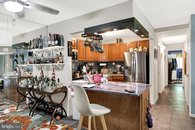 23 Le Forge Ct Unit 23, Chesterbrook, PA 19087 - kitchen featuring stainless steel appliances, brown cabinets, backsplash, a ceiling fan, and dark stone countertops