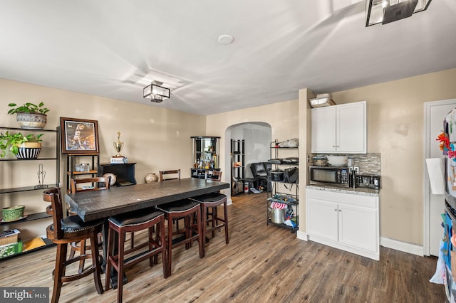 246 Le Carra Dr, Lansdowne, PA 19050 - dining space with arched walkways and dark wood-style floors