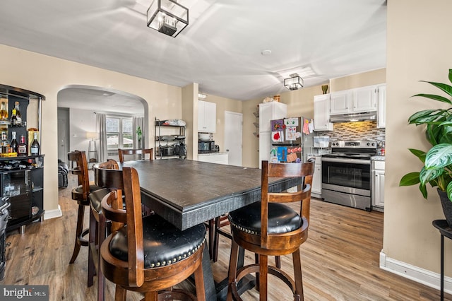 246 Le Carra Dr, Lansdowne, PA 19050 - dining area with arched walkways and light wood-type flooring