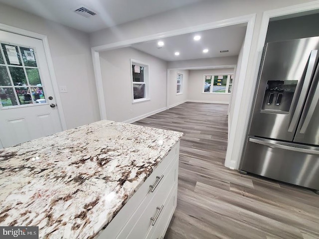 258 Ridge Rd, Browns Mills, NJ 08015 - kitchen with stainless steel fridge, wood finished floors, white cabinets, light stone counters, and recessed lighting