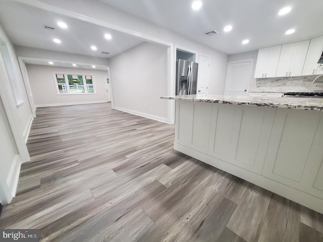 258 Ridge Rd, Browns Mills, NJ 08015 - kitchen with stainless steel refrigerator with ice dispenser, light wood-style flooring, recessed lighting, light stone countertops, and white cabinetry