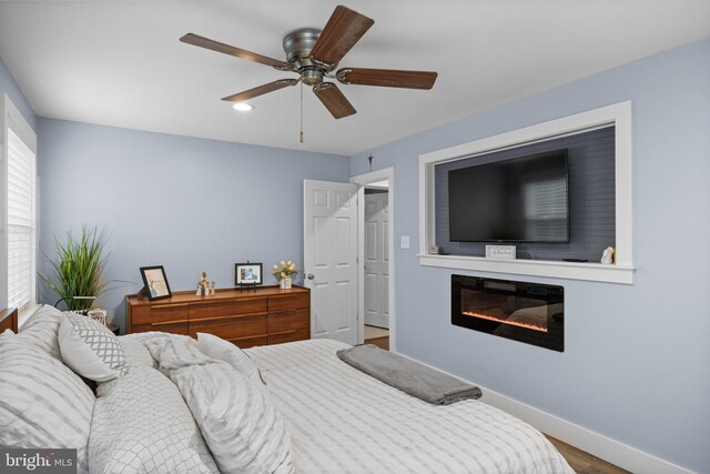 47 Sherwood Ln, Westampton, NJ 08060 - bedroom featuring a glass covered fireplace, wood finished floors, and a ceiling fan