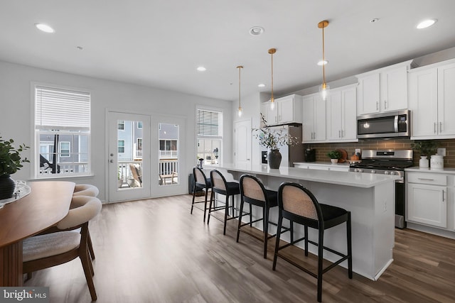 1025 Overlook Way, Laurel, MD 20707 - kitchen with stainless steel appliances, wood finished floors, a center island, backsplash, and a breakfast bar area