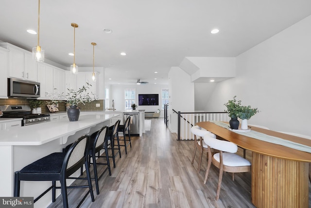 1025 Overlook Way, Laurel, MD 20707 - kitchen with appliances with stainless steel finishes, tasteful backsplash, light wood-type flooring, white cabinets, and recessed lighting