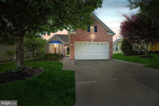16916 Four Seasons Dr, Dumfries, VA 22025 - view of front of house featuring brick siding, a yard, driveway, and a garage