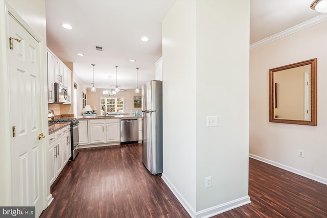 16916 Four Seasons Dr, Dumfries, VA 22025 - kitchen with appliances with stainless steel finishes, dark wood-style flooring, white cabinets, decorative light fixtures, and a peninsula