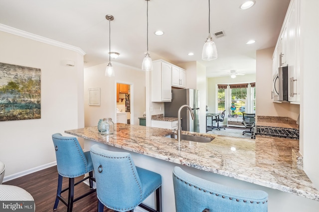 16916 Four Seasons Dr, Dumfries, VA 22025 - kitchen featuring stainless steel appliances, a peninsula, light stone counters, washer / clothes dryer, and white cabinetry