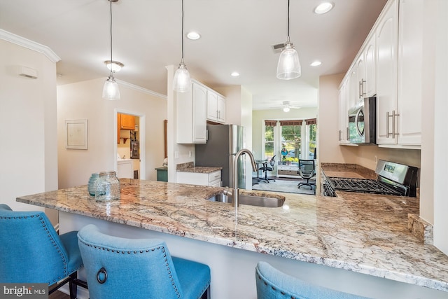 16916 Four Seasons Dr, Dumfries, VA 22025 - kitchen featuring appliances with stainless steel finishes, a peninsula, light stone countertops, a kitchen bar, and recessed lighting