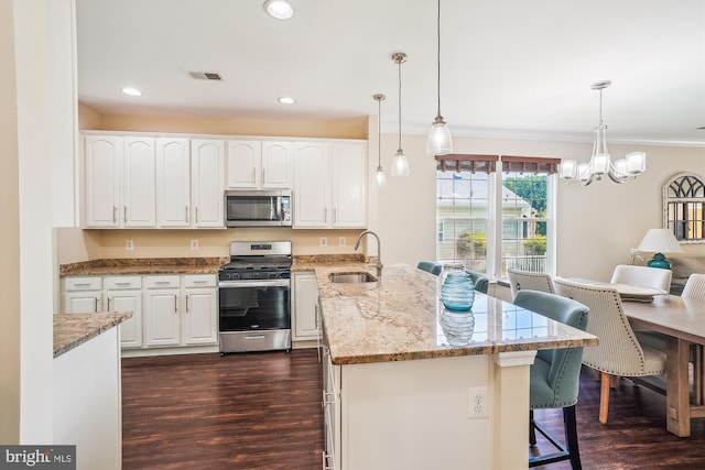 16916 Four Seasons Dr, Dumfries, VA 22025 - kitchen with appliances with stainless steel finishes, a peninsula, dark wood-style floors, a breakfast bar area, and ornamental molding