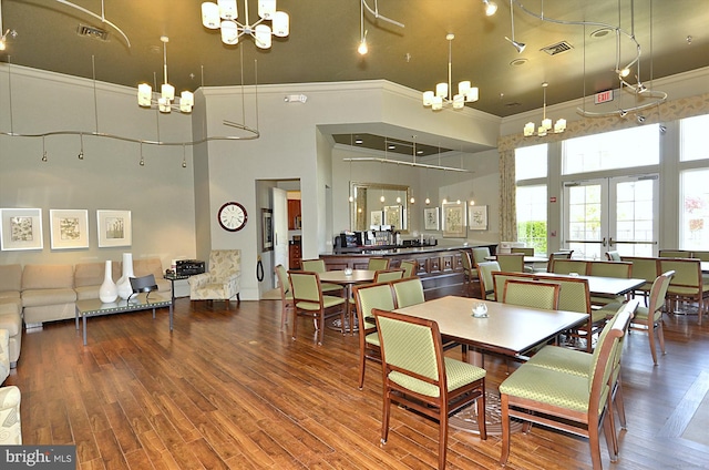 16916 Four Seasons Dr, Dumfries, VA 22025 - dining room featuring a chandelier, a towering ceiling, ornamental molding, and wood finished floors