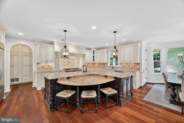 11910 Crayton Ct, Herndon, VA 20170 - kitchen featuring dark wood-style flooring, a large island with sink, a breakfast bar, light stone countertops, and recessed lighting