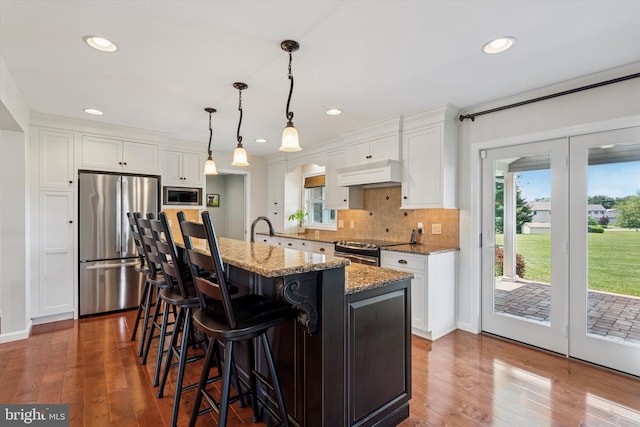 5790 Cedar Glen Dr, Narvon, PA 17555 - kitchen featuring stainless steel appliances, custom exhaust hood, white cabinetry, tasteful backsplash, and light stone counters