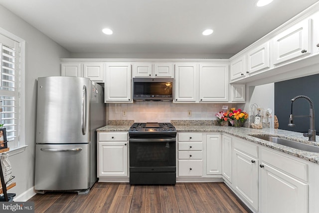 6908 Fairfax Dr Unit 202, Arlington, VA 22213 - kitchen featuring stainless steel appliances, dark wood-style flooring, white cabinets, light stone countertops, and decorative backsplash