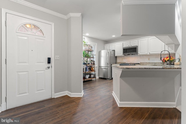 6908 Fairfax Dr Unit 202, Arlington, VA 22213 - kitchen featuring appliances with stainless steel finishes, dark wood finished floors, white cabinetry, light stone counters, and crown molding