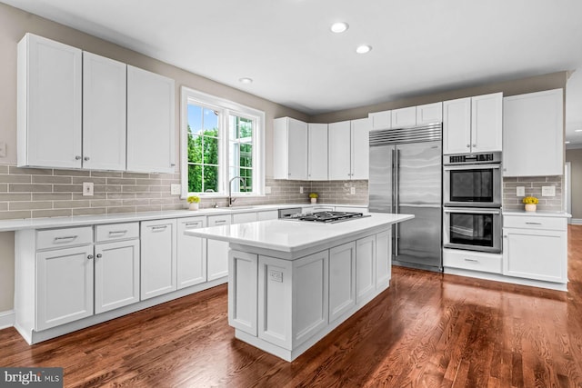 501 Van Lears Run, Villanova, PA 19085 - kitchen with stainless steel appliances, light countertops, tasteful backsplash, white cabinetry, and dark wood-type flooring