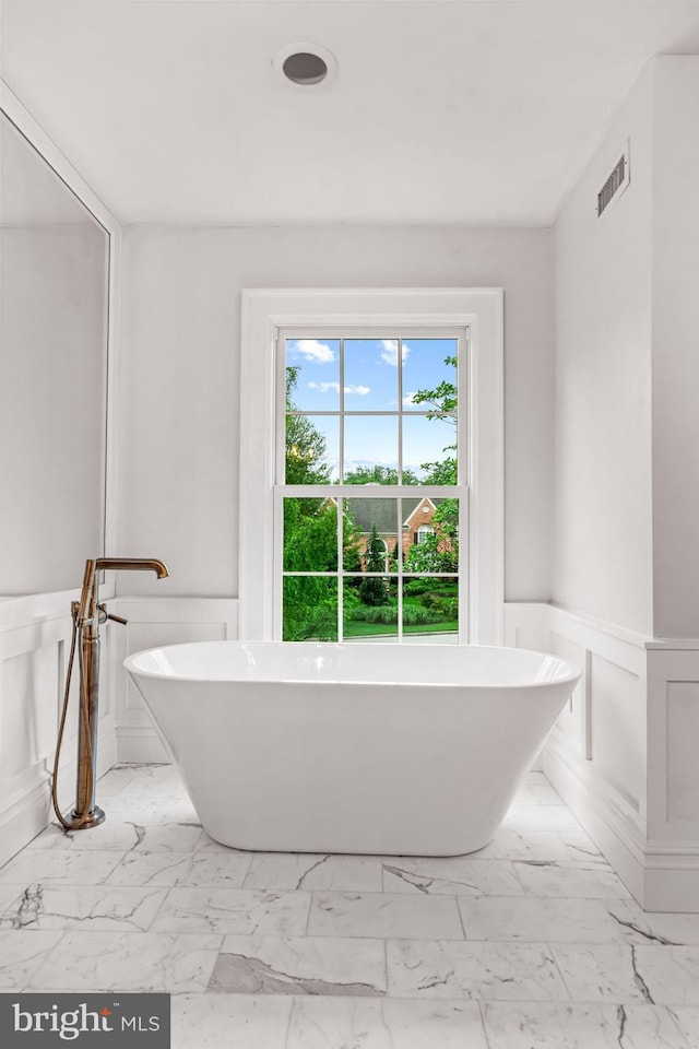 501 Van Lears Run, Villanova, PA 19085 - full bathroom with wainscoting, marble look tiles, a soaking tub, and a decorative wall